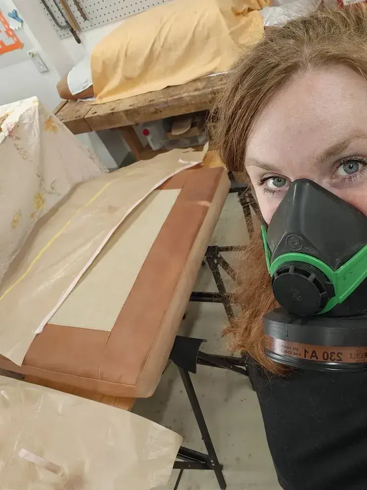Lucienne Hollenstein mit Atemschutzmaske bei der Airbrush-Arbeit an Anilinleder – Sicherheit und Präzision